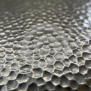 A close-up view of a textured surface resembling a honeycomb pattern. The image