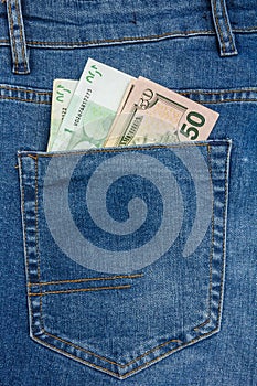 Close Up View to 100 euro and 50 dollar Banknotes Sticking Out From a Blue Jeans Pocket