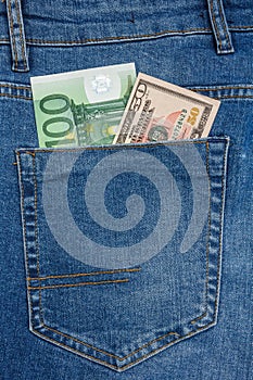 Close Up View to 100 euro and 50 dollar Banknotes Sticking Out From a Blue Jeans Pocket