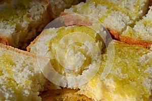 Close-up view to fresh cubic pieces of a high quality bread with olive oil poured on them.