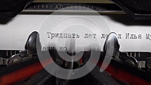 Close up view to paper in typewriter. Author writing typing in russian