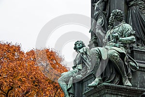 Close up view to part of the bronze Schiller Monument in Vienna with autumn background