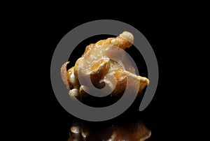 Close up view of top lit single caramel pop corn on black background