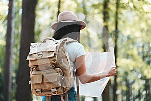 Close-up view on traveling backpack and hipster woman with location map in hands