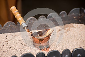 Close up view of turkish coffee prepared on hot sand