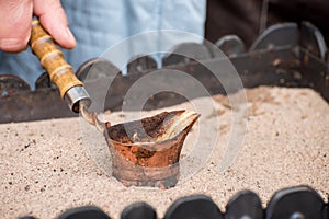 Close up view of turkish coffee prepared on hot sand