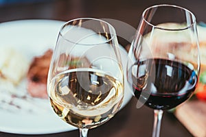 close-up view of two glasses with red and white wine on table