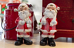 Close up view of two porcelain Santa Claus Dolls on a wooden table