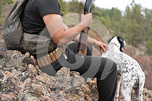 Close up view of an unrecognizable hunter and his dog in the forest.