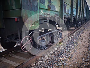 Close up view on used rusted railway freight car bogie with wheel sets with axleboxes, coil springs. Freight train on the railwayC