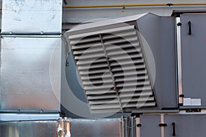 Close-up view of the ventilation louvres of the gray industrial ventilation unit standing outdoor