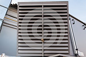 Close-up view of the ventilation louvres of the gray industrial ventilation unit standing outdoor