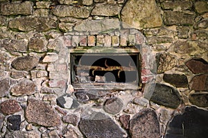 Close up view of a very old brick and stone wall with a window