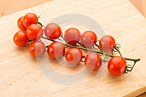 Close up view of vine tomatoes on a wooden board.