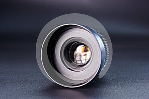 Close-up view of vintage Helios camera lens, black finish, photography gear on dark background, detailed focus rings