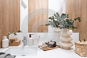 Close up view of washbasin, mirror cosmetics in bathroom