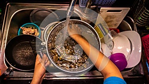 Close up view washing a full of saltwater clams using tap water to remove sand, dirt and salt water