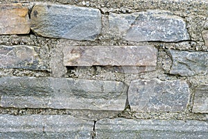Close-up view of a weathered stone wall texture in natural light