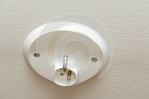 Close up view of white ceiling power socket. Elictricity concept. Power supply elements