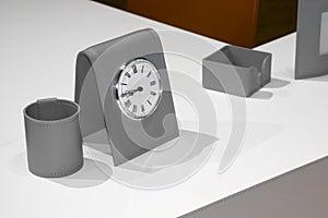 close up view of white desktop with grey accessories for successful work and shiny metal clock