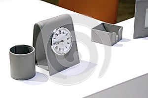 close up view of white desktop with grey accessories for successful work and shiny metal clock