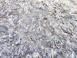 A close-up view of a white and gray oriented strand board. background, texture, pattern, frame, place for text, copy