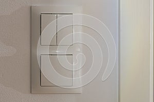 Close up view of white light switch pair on wall . Building construction elements concept.