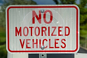 Close up view of a white and red sign that reads No Motorized Vehicles