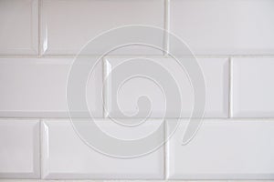 Close up view of white tiled kitchen wall. Typical interior design idea. Clean big rectangular tiles in modern architecture.