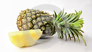 Close up view of whole and sliced ripe pineapple isolated on white background