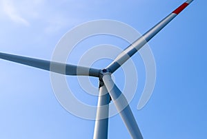 Close up view on wind mills producing electricity on a sunny summer day