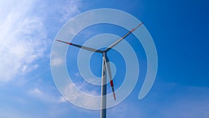 Close up view on wind mills producing electricity on a sunny summer day