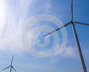 Close up view on wind mills producing electricity on a sunny summer day