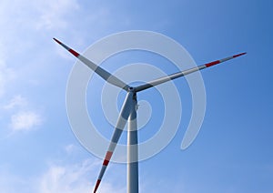 Close up view on wind mills producing electricity on a sunny summer day