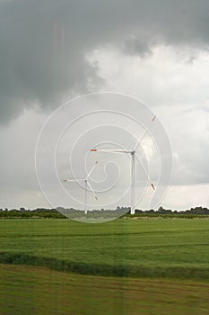 Close up view of wind turbine in rural Germany in summer with cloudy sky background