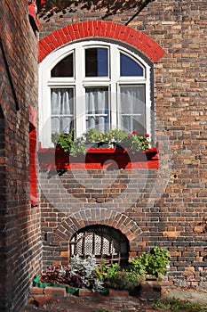 Close up view of windows of red brick old building in Nikiszowiec historic mining district of Katowice, Poland photo