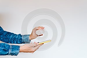 close up view of a woman cleaning mobile phone with disinfectant. Hygiene and coronavirus covid-19 concept