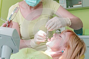 Close up view of woman dentist working at her patients teeth in dentist office