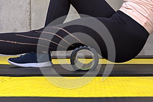 Close up view of woman exercising with foam roller