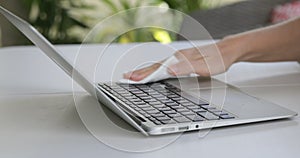 Close up view of woman hand using antibacterial wet wipe for disinfecting laptop