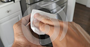 Close up view of woman hand using antibacterial wet wipe for disinfecting phone