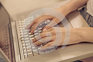 Close up view of woman hands keyboarding on laptop.