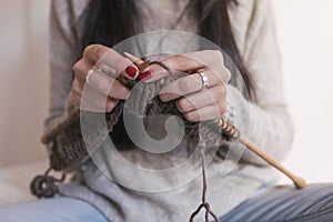 close up view of woman hands knitting on bed. Working at Home, indoors