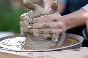 Close-up view of woman hands working on pottery wheel and making clay pot. Workshop on modeling on the potter`s wheel. Young woman