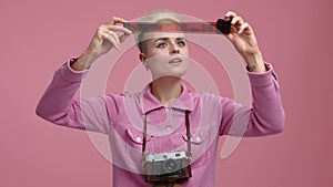 Close-up view of a woman observing film negative after photo session