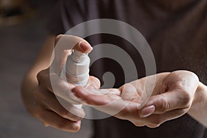 Close up view of woman person using small portable antibacterial hand sanitizer on hands. Coronavirus epidemic prevention concept