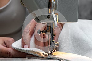Sewing fabric bouncle on a sewing machine at home workshop