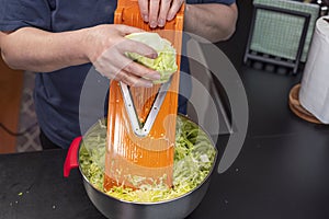 Close up view of woman shredding cabbage.