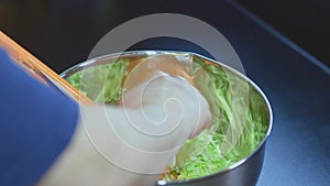 Close up view of woman shredding cabbage.