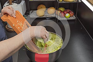 Close up view of woman shredding cabbage.